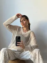 Sweater de hilo color crudo, tejido con calados grandes.