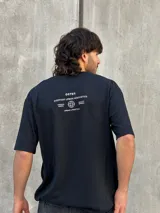 Remera negra de corte oversize con estampado en la espalda con la leyenda "OSTEN EVERYDAY URBAN AESTHETICS PREMIUM BASICS QUALITY APPAREL URBAN LIFESTYLE".