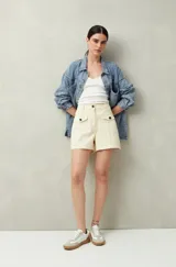 Short blanco de tiro alto con bolsillos delanteros con solapa y botones a la vista.