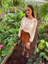 Buzo tejido color crudo con mangas largas y calado en el frente.