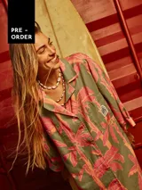 Vestido camisero de lino con estampado de palmeras en tonos rosados y verdes.