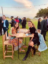 Vestido corto negro de terciopelo con bordado de flores blancas en la espalda, escote en V y corte holgado.