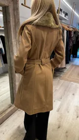 Tapado color camel con cuello de piel sintética color beige, doble botonadura y lazo para ajustar en la cintura.