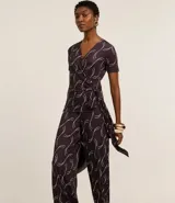 Mono largo de microfibra con estampado geométrico en tonos marrones y blancos. Tiene escote en V, mangas cortas y lazo ajustable en la cintura.