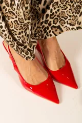 Zapato de charol con punta afilada, diseño elegante y tacón stilettos.