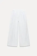 Pantalón palazzo blanco de lino, de tiro alto con cintura elástica ajustable con lazada.