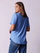 Blusa celeste de tejido piqué, con cuello a la base y escote en V. Tiene mangas cortas amplias.