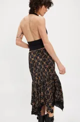 Falda midi negra con estampado floral en tonos marrones, corte al bies, ruedo asimétrico con encaje y cintura alta.