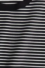 Remera de algodón a rayas horizontales blancas y negras, con cuello redondo y mangas cortas.