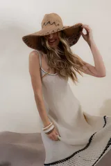 Vestido tejido a crochet color crema, con breteles finos y detalles de terminación en negro.