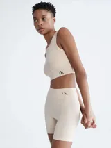 Shorts de ciclismo color beige, de tiro alto, con logo de Calvin Klein en la cintura.