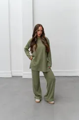 Conjunto verde oliva de punto morley, compuesto por un buzo de corte holgado con mangas largas y aberturas laterales, y un pantalón palazzo de tiro alto.