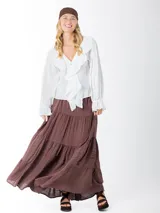 Falda larga marrón de estilo campesina, confeccionada en lino rayón liviano, con corte en capas y detalles de costuras verticales.