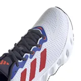 Championes Adidas Switch Run blancos con detalles en azul, gris y naranja. Presentan las tres tiras características de la marca en color rojo.