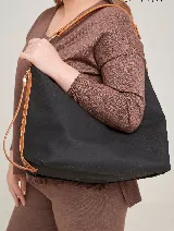 Bolso negro tipo tote con asas de cuero color marrón claro.