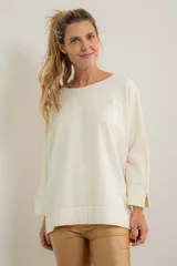 Remerón beige de corte amplio, con escote redondo y mangas largas.