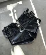 Short negro de cuerina con cierre frontal y múltiples correas con hebillas plateadas.