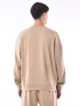 Buzo gris de corte holgado con cuello redondo y mangas largas.