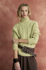 Sweater color verde claro, de tejido de punto trenzado, con cuello alto y mangas largas.