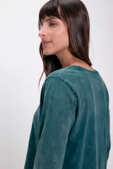 Remera verde de manga larga con cuello redondo y corte holgado.