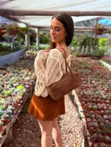 Cartera baguette de cuero color marrón con forro interno de tela.