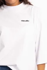 Remera blanca de corte cuadrado con cuello subido y mangas 3/4 amplias.