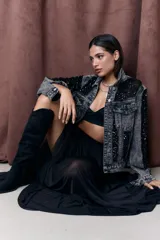 Campera de jean gris oscuro con efecto lavado y apliques de lentejuelas negras en hombros, mangas y bolsillos.