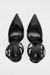 Zapato de tacón destalonado negro acharolado con tiras finas cruzadas ajustables con hebilla al tobillo y punta fina.