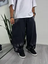 Pantalón de jean negro de corte amplio, con efecto desgastado en la parte inferior.