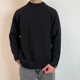 Sweater negro de tejido de punto grueso, con cuello alto y mangas raglán. Corte holgado.