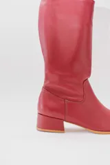 Bota de caña alta de cuero color rojo, con cierre lateral y taco cuadrado de 4 cm.