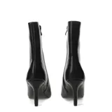 Botín de mujer color negro, de material sintético, con punta fina y taco alto. El cuerpo del botín está decorado con tachas metálicas plateadas.