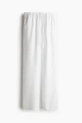 Pantalón blanco de tejido liviano con lino, de tiro bajo con elástico revestido y cordón para ajustar en la cintura, bolsillos al bies y piernas rectas.