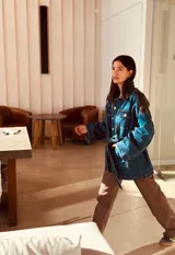 Campera tipo trench de jean con corte oversized y cinto para ajustar. Presenta cuero ovino extra blando en espalda y cuello. Cierre con botones dorados.