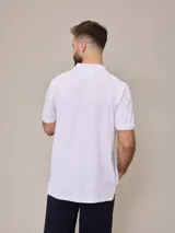 Chomba negra de piqué de algodón, corte clásico, con cuello y mangas acanalados y tapeta con dos botones blancos. Logo bordado en el pecho.