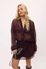 Vestido corto color verde lima, estilo camisero, confeccionado en chiffon transparente. Tiene cuello camisero, mangas largas abullonadas y elástico en la cintura.