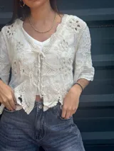 Camisa negra con detalles de crochet color crema, escote en V y mangas 3/4.
