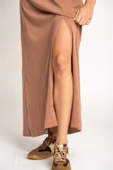 Vestido largo color visón de algodón con cuello redondo y mangas cortas. Presenta un tajo alto en el frente.