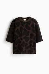 Buzo boxy de punto jacquard suave, con estampado de leopardo en tonos marrón oscuro y negro. Presenta cuello redondo acanalado, hombros caídos y mangas al codo.
