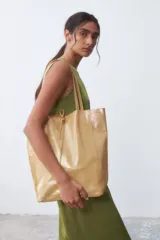 Bolso tipo shopper grande color dorado con textura brillante.
