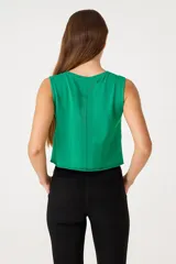 Musculosa verde con estampado de texto y dibujo de una flor, sin mangas, corte cropped y cuello redondo.