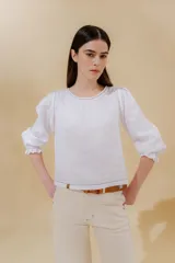 Blusa color beige de lino 100% con mangas balloon y detalle de tablón en el hombro. Tiene mangas largas con detalle de 2 pespuntes elásticos en contratono, el recurso del elástico es ideal para remangarse la manga generar más volumen. Calce recto, largo por arriba de la cadera.