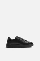 Zapatillas urbanas de cuero sintético color negro, con cordones y suela chunky.