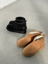 Pantubotas bajas de gamuza con forro de pelo sintético, disponibles en dos colores.
