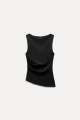 Musculosa negra con cuello barco, sin mangas, detalle de pliegues laterales y bajo asimétrico.