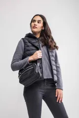 Bandolera negra de poliéster con correa regulable y asa. Tiene bolsillos con cierre.