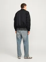 Campera bomber negra Jack & Jones, liviana y cómoda, con cuello estilo baseball, mangas largas con puños acanalados, cierre con cremallera, bolsillos al frente con botón y bolsillo en la manga.