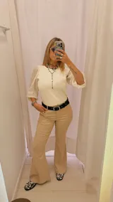 Pantalón de vestir color beige, de tiro alto, corte recto y terminación acampanada.