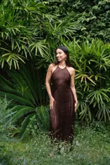 Vestido largo marrón con escote halter y flecos largos.