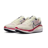 Championes de running Nike Vomero 17, color crema con detalles en azul marino y rojo.